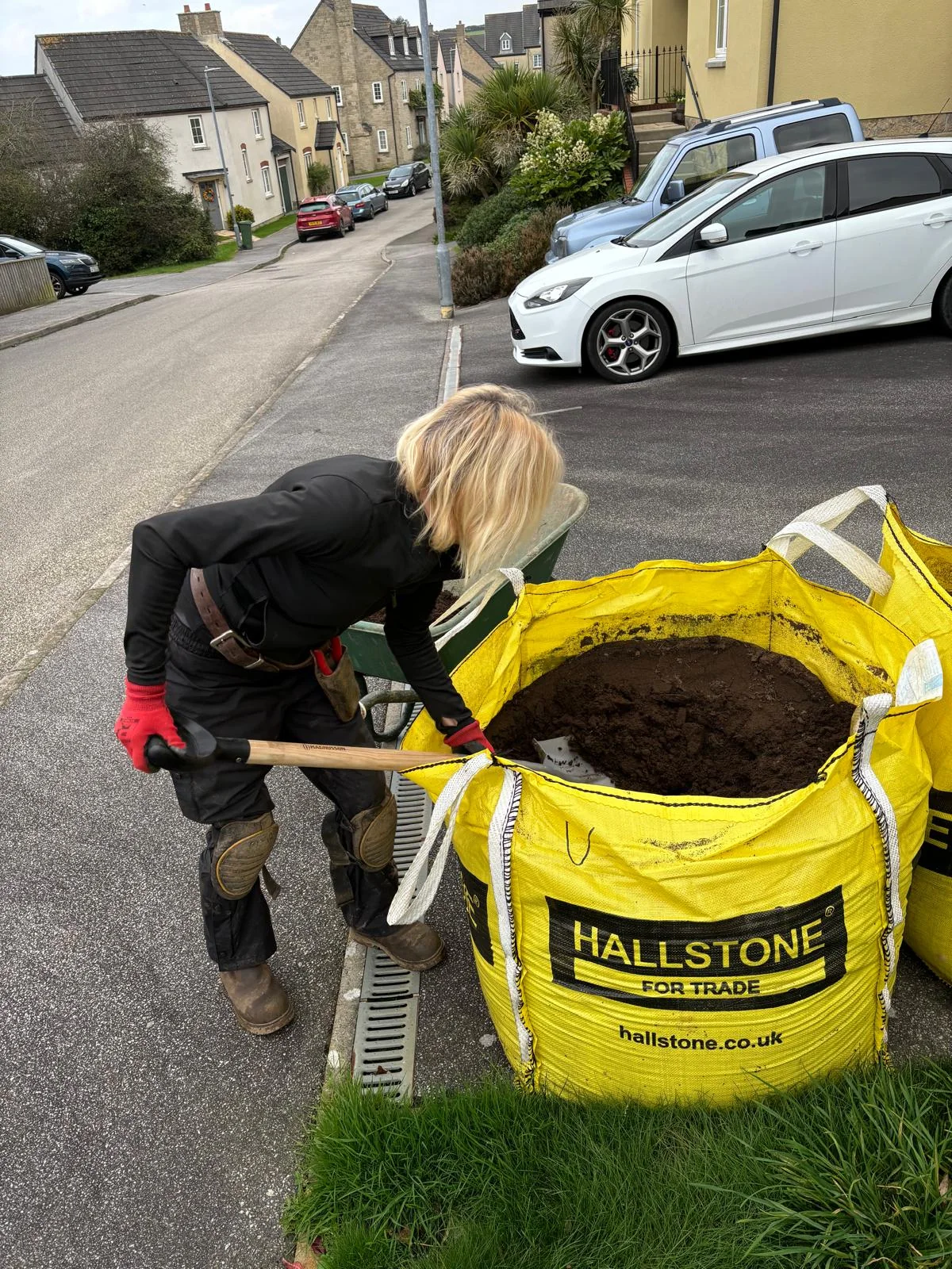 The designer shovelling soil while working outdoors