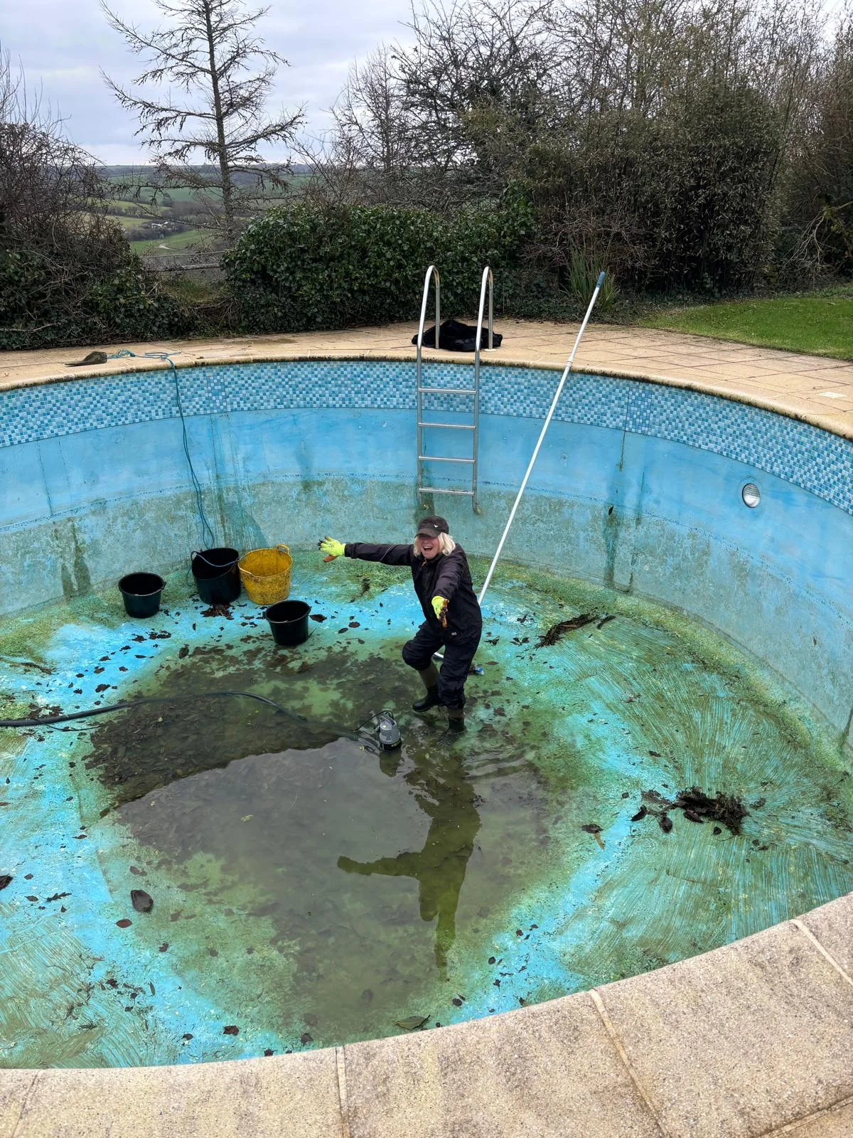 The designer laughing while working in an empty outdoor pool